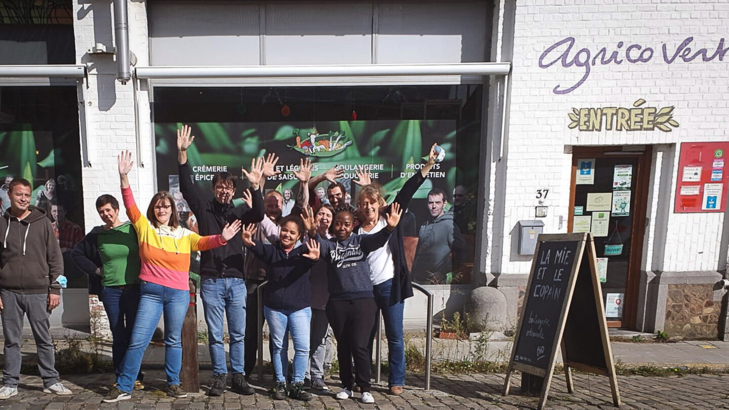 L'équipe d'Agricovert pose pour la photo devant l'enseigne de la coopérative.