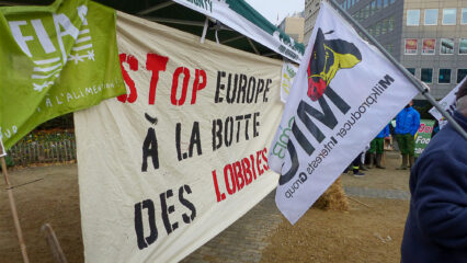 Groupe de manifestants portant une banderole sur laquelle est inscrit l'Europe à la botte des lobbies.