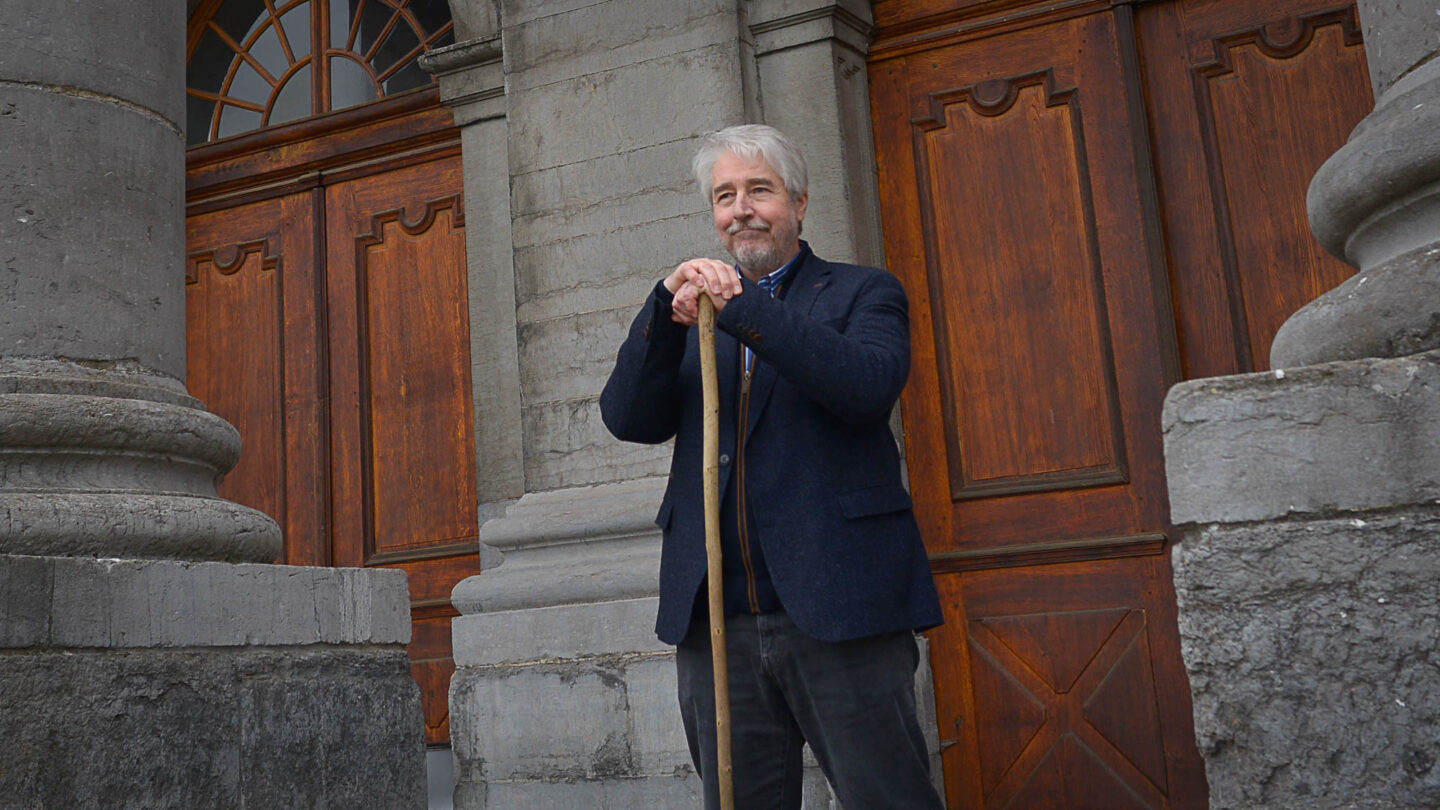 Bruno Schiffers pose debout devant une des vieilles portes de Gembloux Agro-Bio-Tech.