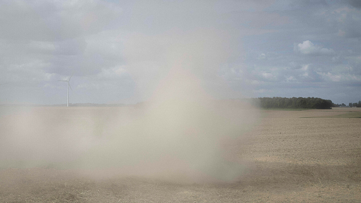 Nuage de poussière soulevé par un tracteur lors du déchaumage.