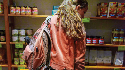 Une femme, vue de dos, fait ses courses dans une épicerie sociale.