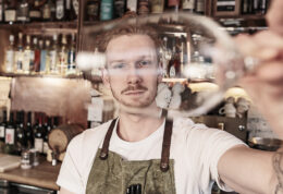 Young redhead barman working at the bar